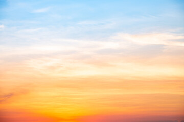 Sunset or sunrise sky with a vibrant gradient of orange, gold, and soft blue. Clear atmosphere with wispy clouds. Peaceful, natural light background. hope, freedom, new day and inspirational Concepts