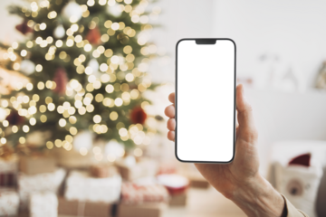 Phone mockup in hand over christmas tree, stars, gifts and decoration, Mobile phone with blank white phone screen isolated transparent PNG, Winter holiday online shopping, xmas 
advertisement concept