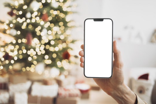 Phone mockup in hand over christmas tree, stars, gifts and decoration, Mobile phone with blank white phone screen isolated transparent PNG, Winter holiday online shopping, xmas 
advertisement concept