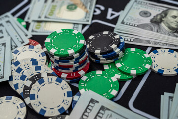 Casino poker chips on US hundred dollar bills representing gambling, luck, risk and financial winnings