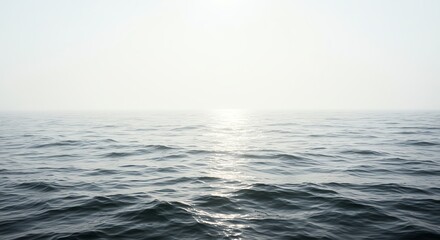 Fototapeta premium Ocean surface reflecting sunlight with hazy horizon