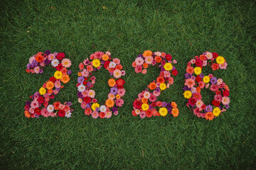 Spring nature illustration with green grass, decorative flowers, and colorful 3D letters for a holiday celebration symbol