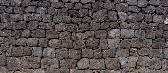 A volcanic stone wall stands with timeless texture