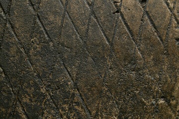 concrete textured surface with a repeating diamond-shaped, wet