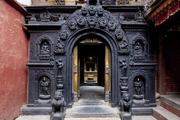 Intricate stone gateway adorned with Buddhist figures, symbolizing devotion and cultural heritage.
