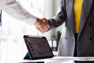 Two diverse professional business men executive leaders shaking hands at office meeting

