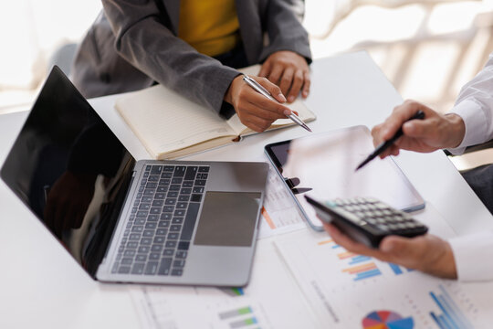 Team og Business work on calculator and laptop for do math finance on wooden desk in office and business working background, tax, accounting, statistics and analytical research concept
 - Powered by Adobe