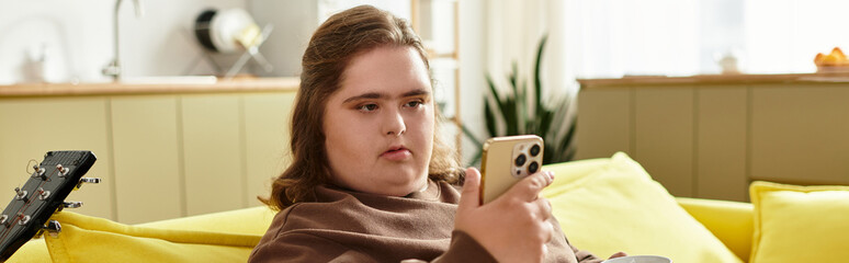 Young woman with Down syndrome enjoys relaxing time at home with her smartphone