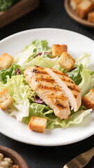 Delicious grilled chicken caesar salad with croutons and dressing on plate