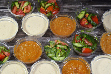 many assorted salads of Tahini Tahina, a Middle Eastern condiment made from toasted ground hulled sesame, green salad with slices of cucumber, tomatoes and green arugula rocket and beef liver salad