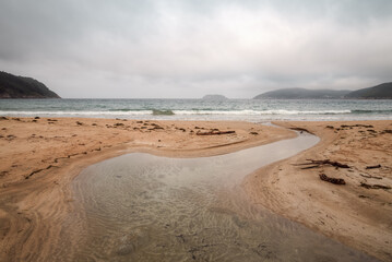 A freshwater stream meanders into the Vilela beach