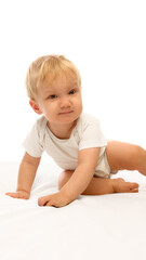 Happy baby crawling forward smiling with playful energy on bright soft white bedding. Concept of early learning, confidence, and curiosity in joyful childhood moments.