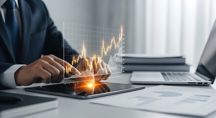 Businessman analyzes stock market data with glowing chart overlay on a tablet while working at desk.