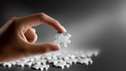 Hand holding puzzle piece over assembled pieces concept of problem solving