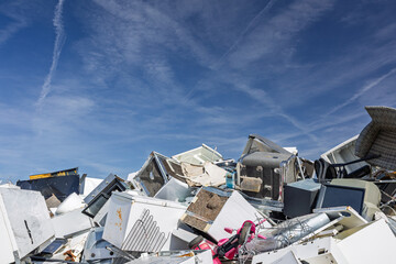 Junkyard Pile of Discarded Appliances and Furniture Under a Clear Blue Sky, Chaotic and Industrial