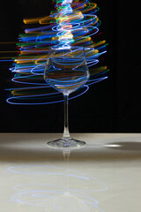 Wine glass with water and neon light on marble table and black background