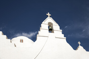 traditional greek chapel with bell tower on deep blue sky background. minimalist white orthodox architecture. religion concept. greek island atmosphere 