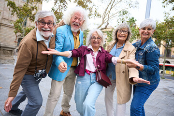 Group of senior friends posing playful in city