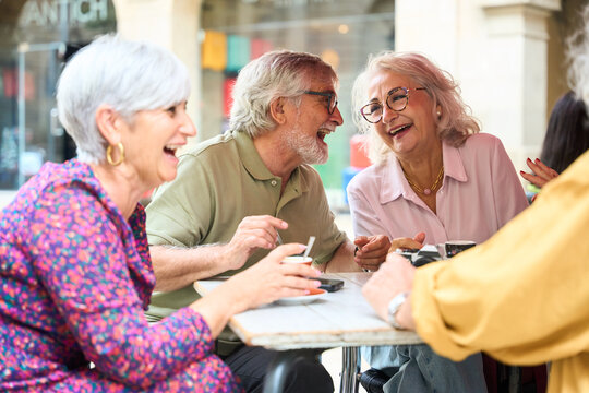 Seniors friends laughing together at cafe terrace - Powered by Adobe