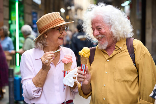 Senior couple enjoying ice cream cones on street