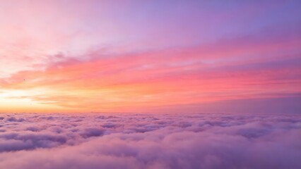 Fototapeta premium Sunrise paints the sky in vibrant pinks and purples above a sea of clouds.