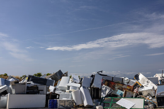 Stacked Pile Of Scrap Metal And Broken Chairs In A Junkyard Under A Bright Blue Sky