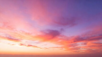 Fototapeta premium Vibrant pink and purple clouds streak across the sky at sunset.