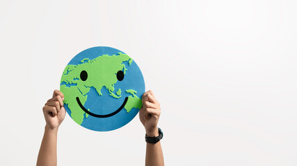 Hands holding a smiling world paper cutout to eco-friendly and saving the planet for responsibility to sustainable environment, environmental awareness. climate change, Earth Day and ESG concept.