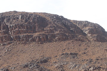 A large rocky mountain landscape under a bright sky