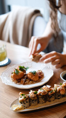 A beautiful girl eats Japanese sushi rolls with chopsticks, smiling with pleasure