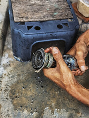 Clogged sink pipe in hands ,A plumber cleans a clogged siphon pipe of a sink in the kitchen. Clogged rusty water trap siphon and drainage pipe cleaning. Home plumbing maintenance service. DIY concept