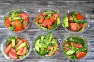 Traditional Arabic green salad with slices of cucumber, tomatoes and green arugula rocket mixed together, pieces of fresh vegetables mixed together, healthy food and dietary concept, Fresh salad