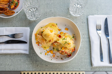 Delicious dish of dumplings topped with rich sauce served at a trendy restaurant during lunch hour