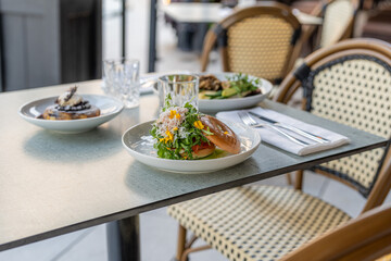 Fresh salad and gourmet dishes on a sunny restaurant patio during lunch hour