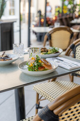 Outdoor dining with fresh salads and a flavorful sandwich at a cozy cafe during a sunny afternoon