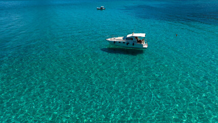 Aerial view of a motorboat vacationing in the clear and turquoise sea. Boat holiday concept.