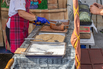 Baker preparing traditional chimney cake at market stall