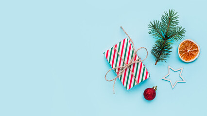 Fototapeta premium Collection of Christmas objects - gift box, frame, eve fir, dried orange, pine cone, star. New Year and winter minimal holiday frame composition. Flat lay, top view, place for text.