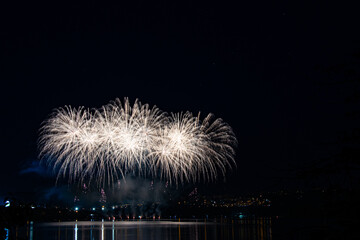 Colorful and bright fireworks at the dark with bounce in the river near by the firework. Good as a wallpaper or background.