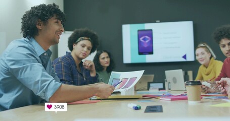 Presenting man in light blue shirt holding app mockups in meeting room with laptops, copy space