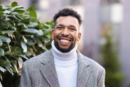 Portrait of handsome man in suit near bush outdoors - Powered by Adobe