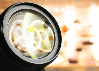 Closeup view of camera lens on blurred background