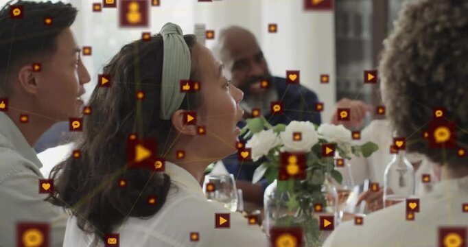 Friends pouring wine at table while chatting with social media icons appearing mapping interactions