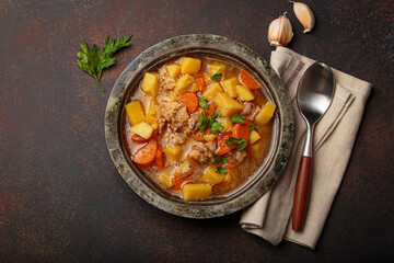 Hot chicken stew or soup with tender chicken pieces, chunky potatoes, and vibrant carrots garnished with fresh parsley in rustic bowl, comfort food for autumn and winter