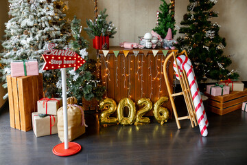 Golden numbers 2026 on the background of Christmas trees and Christmas decorations with garlands and lights. New hour