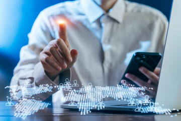 Man interacts with digital interface while using smartphone and laptop in an office setting
