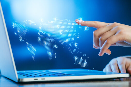 Digital interaction with global currency map displayed on laptop screen in a modern workspace setting - Powered by Adobe
