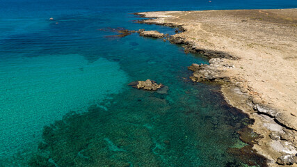 Obraz premium Aerial view of a rocky coastline facing a turquoise sea. It's located in the Zingaro Nature Reserve, near San Vito Lo Capo in Sicily, Italy.