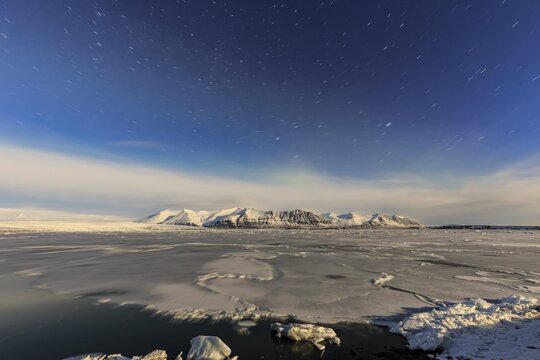Night shot of an icy lake in front of Bergen, star trails, Vatnaj&ouml;kull, J&ouml;kulsarlon, Iceland