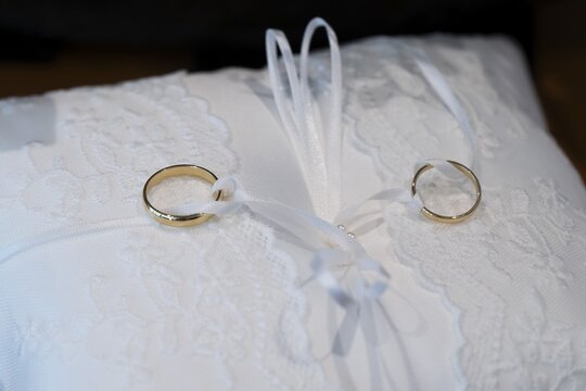 Wedding rings on an ornate white cushion